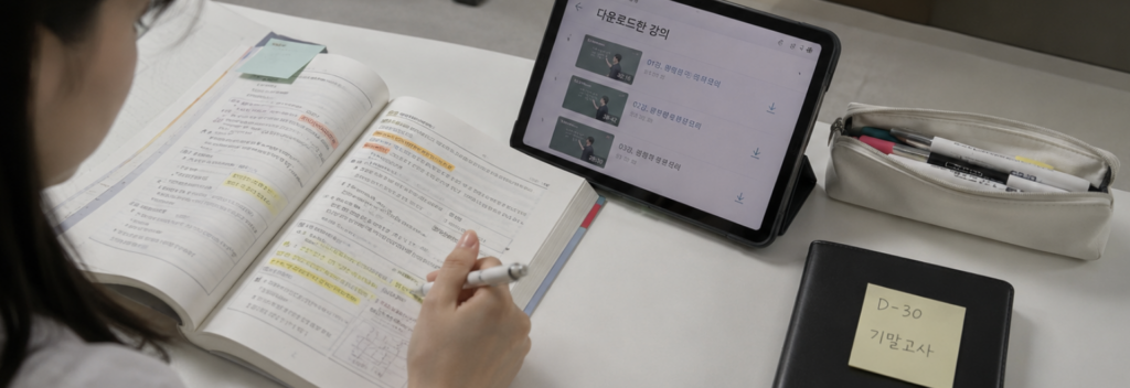 태블릿에 다운로드된 대성 인강 목록을 띄워두고 학습 계획표를 함께 보는 장면